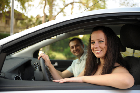 Happy couple smiling from their new car